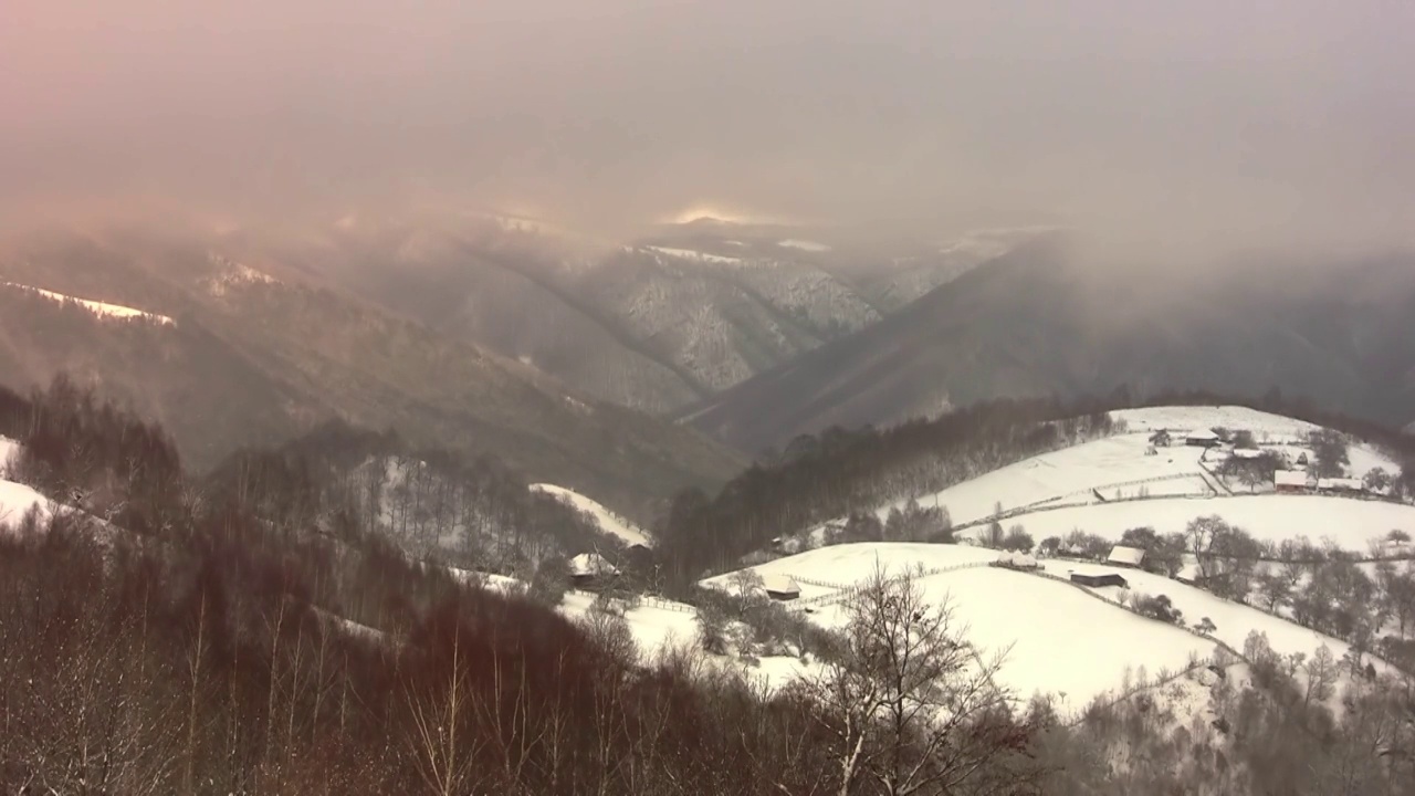 在寒冷的冬天，时间流逝和俯瞰覆盖着雪的山脉视频素材