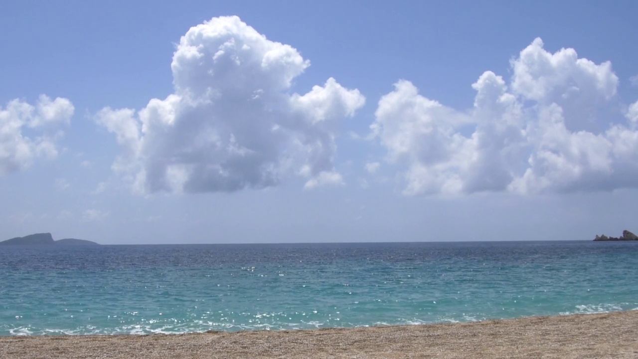 清澈湛蓝的海水和布满小鹅卵石的海滩的全景视频素材