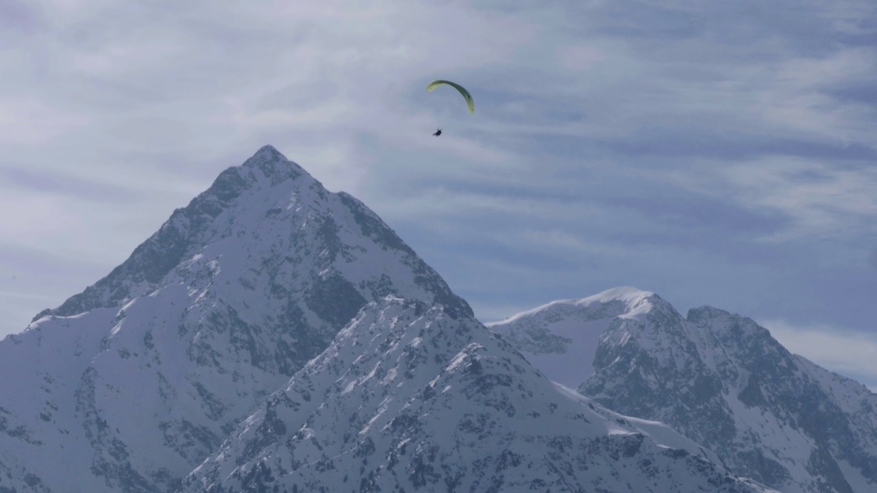 高空滑翔伞在雪峰上空飞行视频素材