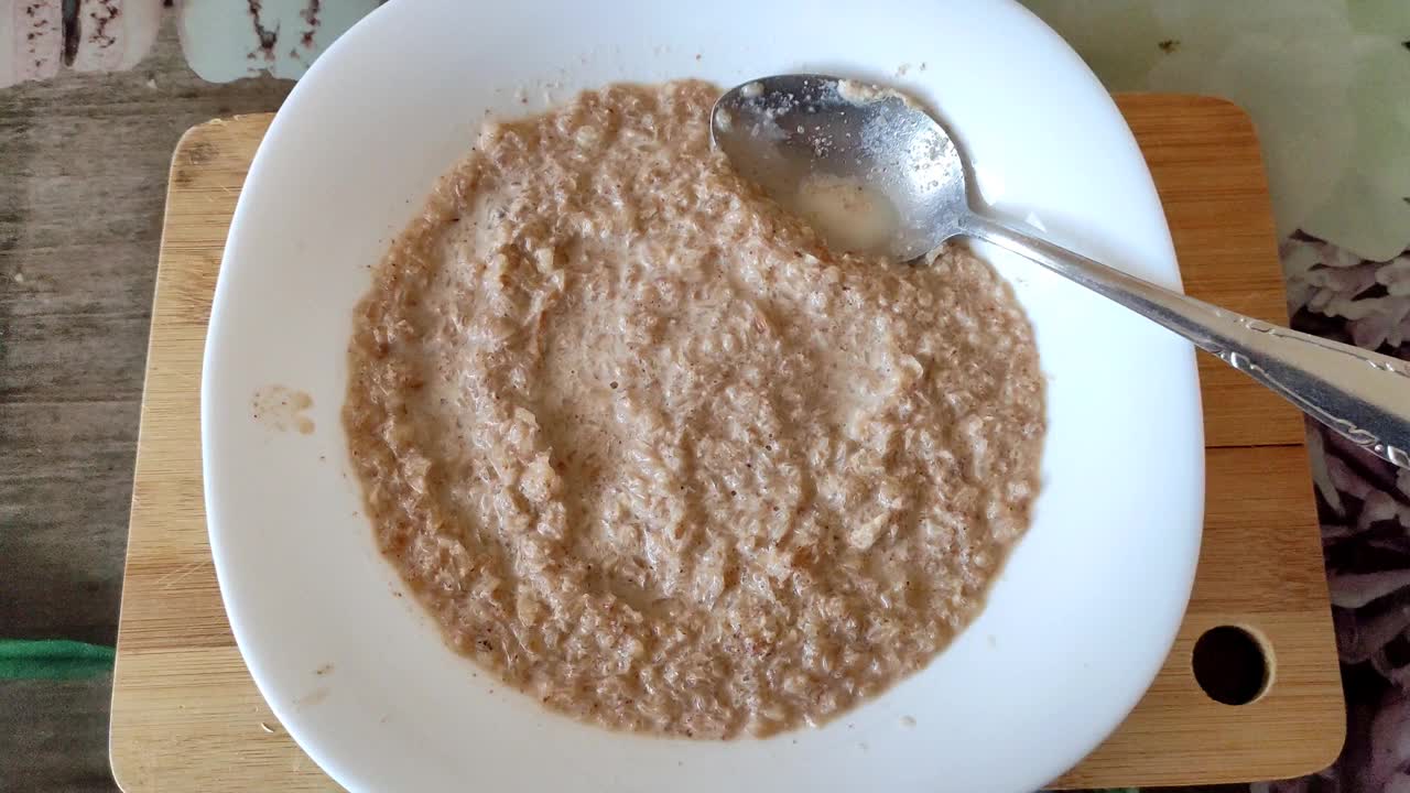 用勺子搅拌荞麦粥，冷却食物视频素材