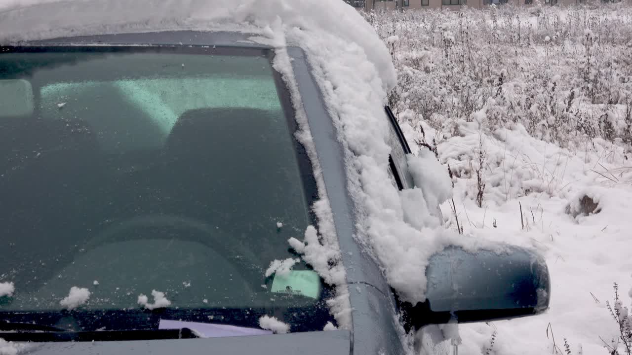 正在清理汽车挡风玻璃上的冰雪视频素材