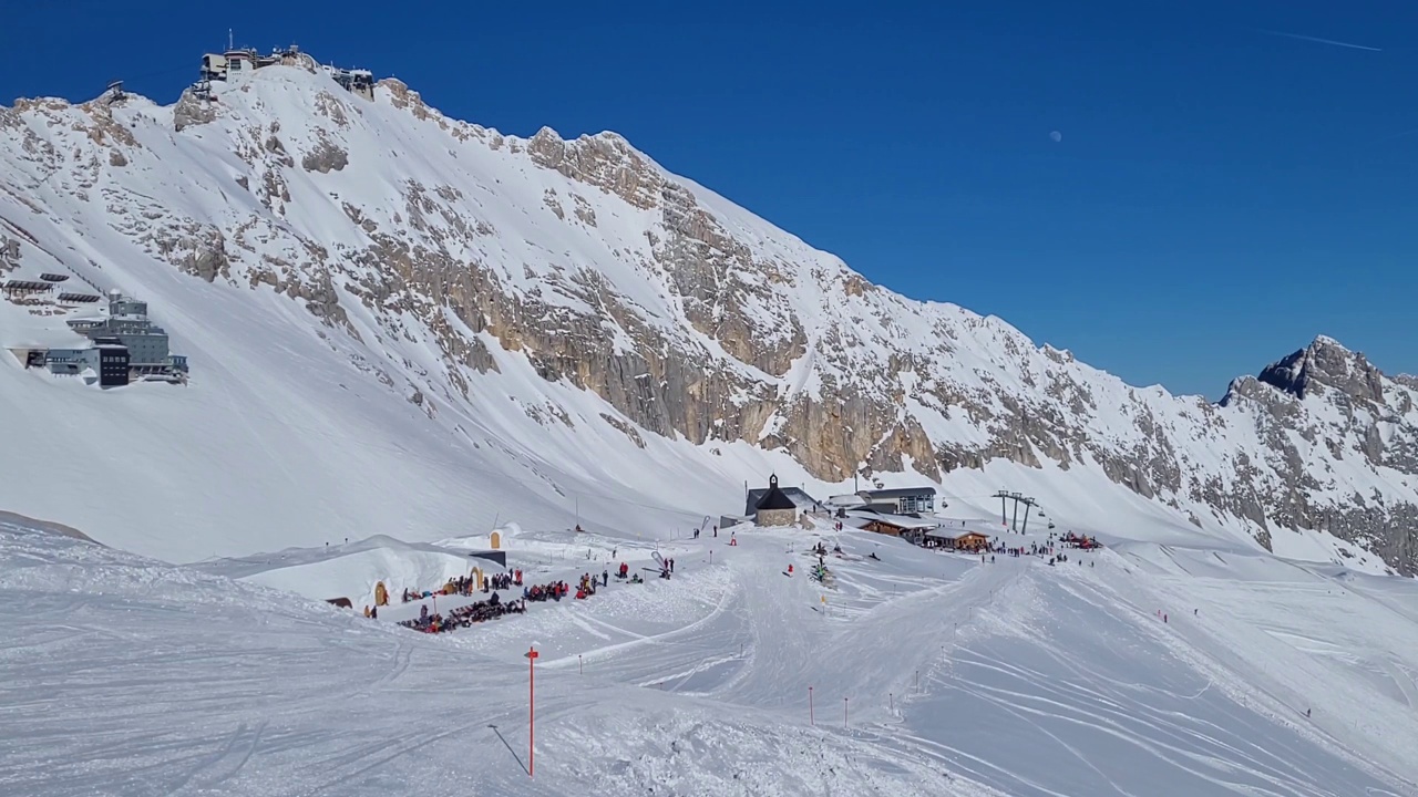 德国阿尔卑斯山滑雪胜地的全景。在一个阳光明媚的冬日，滑雪坡上的滑雪者。视频素材