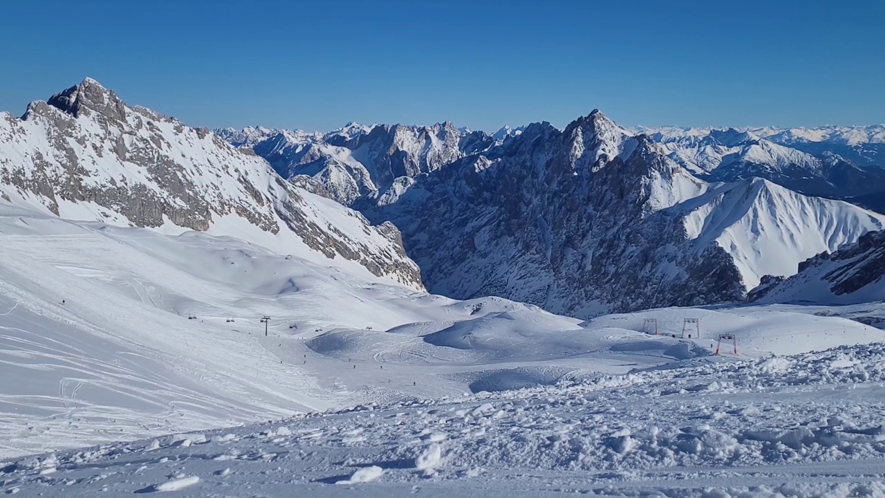 德国阿尔卑斯山滑雪胜地的全景。在一个阳光明媚的冬日，滑雪坡上的滑雪者。视频素材