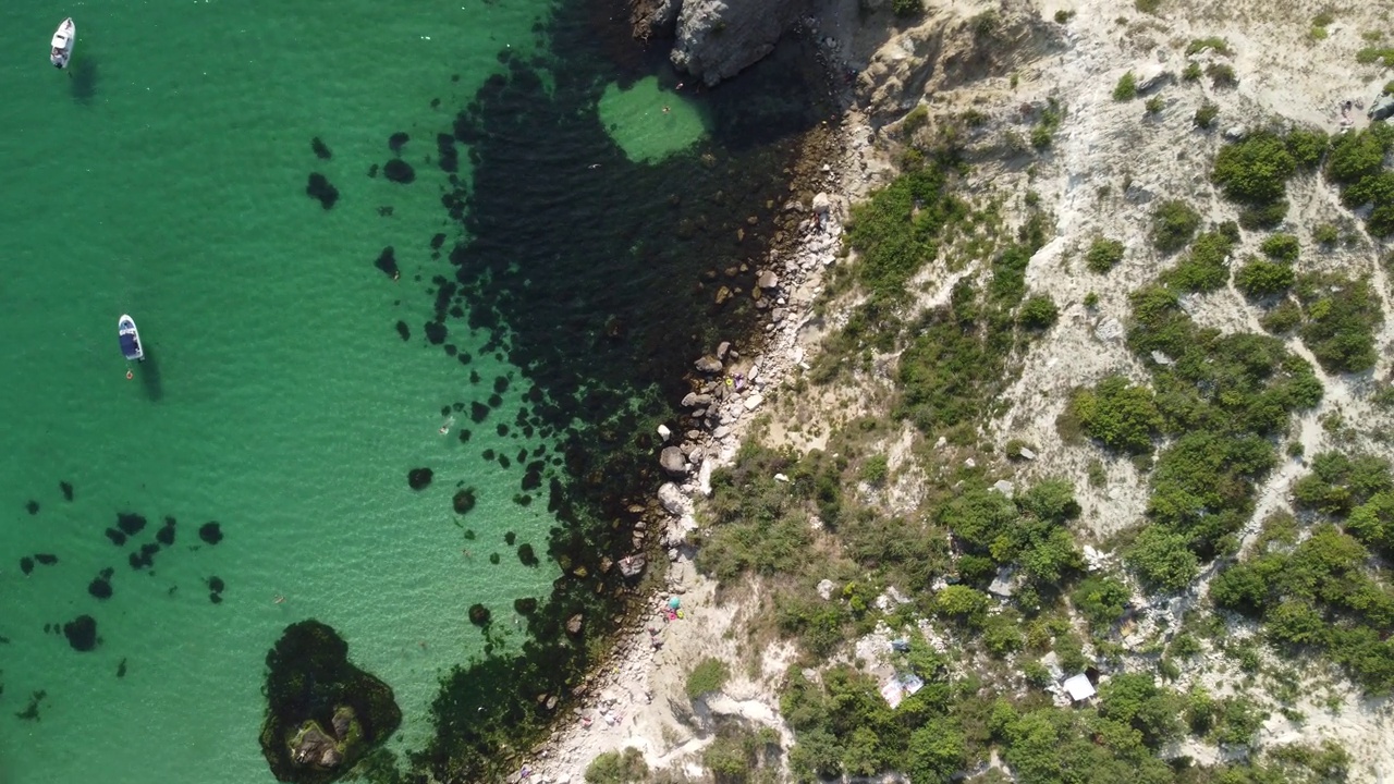 空中全景海景与湛蓝的大海和岩石海岸。在岩石的背景下，美丽的泻湖上的游艇。是夏季旅游和度假的理想目的地视频素材