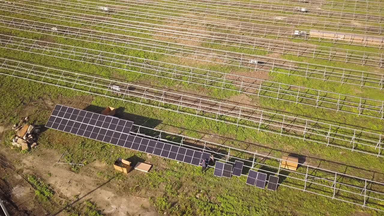 在绿地上建造太阳能发电厂的鸟瞰图。生产清洁生态能源的电板装配视频素材