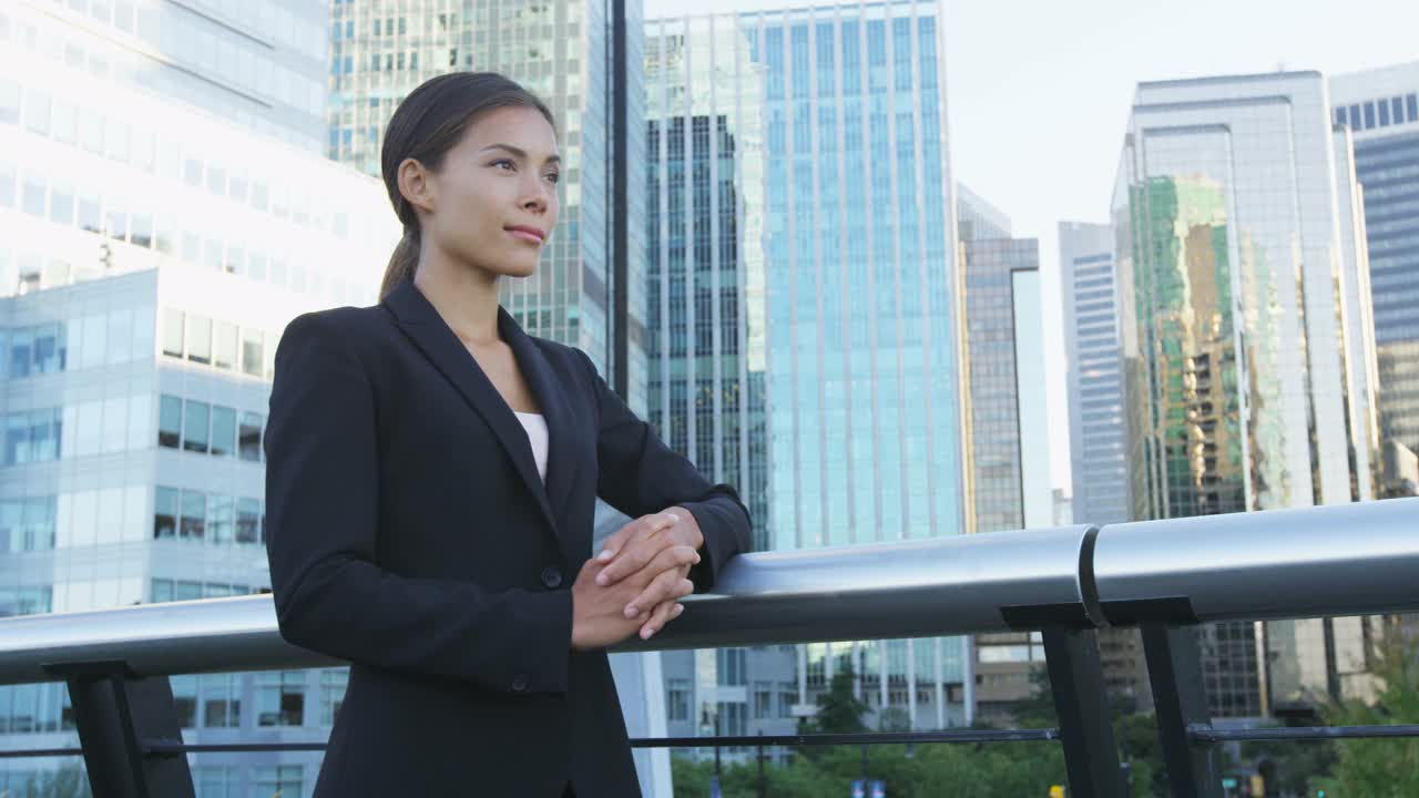 亚洲的女商人。严肃的商业女性肖像。中国专业人士在城市背景下穿着黑色西装，生活在市中心。双臂交叉的自信女士视频素材