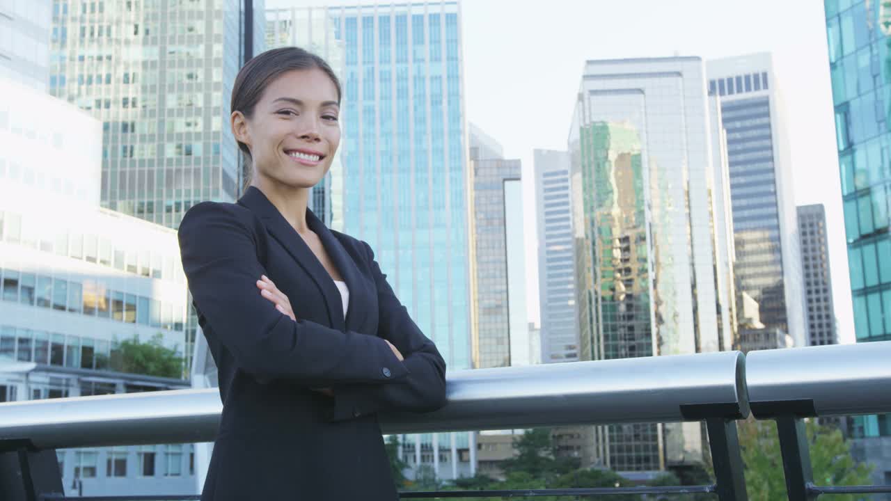 女商人肖像年轻女性城市职业女商人在西装站在办公大楼外交叉武装。自信成功的多元文化的中国亚裔/高加索女性视频素材