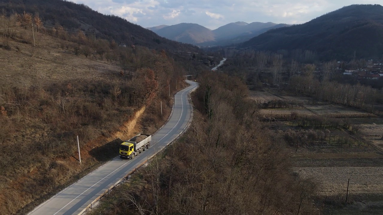 在塞尔维亚Knjazevac附近，秋冬的一天，卡车行驶后的道路上的高角度鸟瞰图无人机视频视频素材