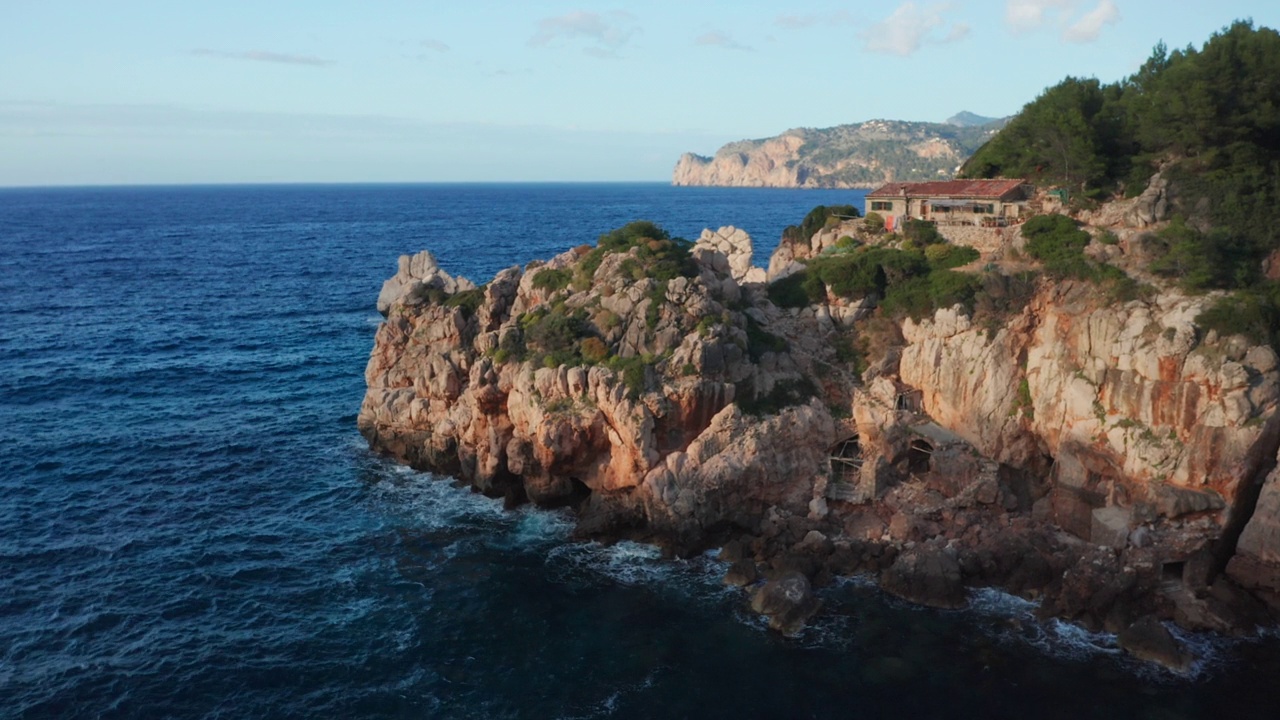 无人机在蓝海上空飞向伊比沙岛的岩石海岸线视频素材