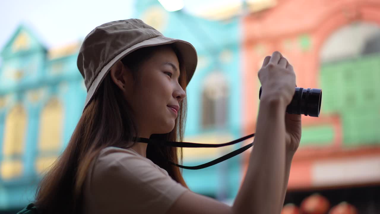 亚洲年轻女性背包客使用相机拍摄地点，同时旅行与快乐的情感表达，独自旅行在生活方式度假夏天。视频素材