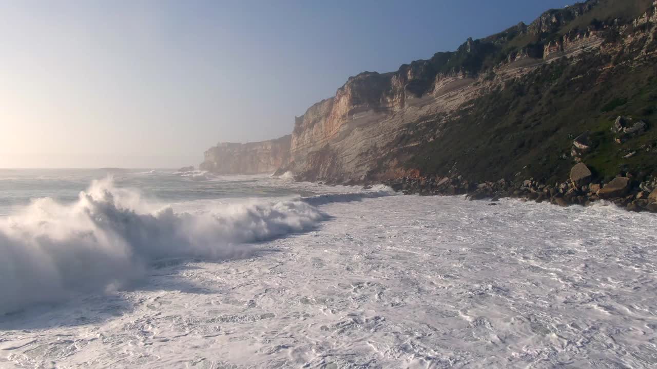 空中倾斜拍摄的照片显示了在葡萄牙纳扎尔海滩的海浪，冲浪者以拥有世界上最大的海浪而闻名视频素材