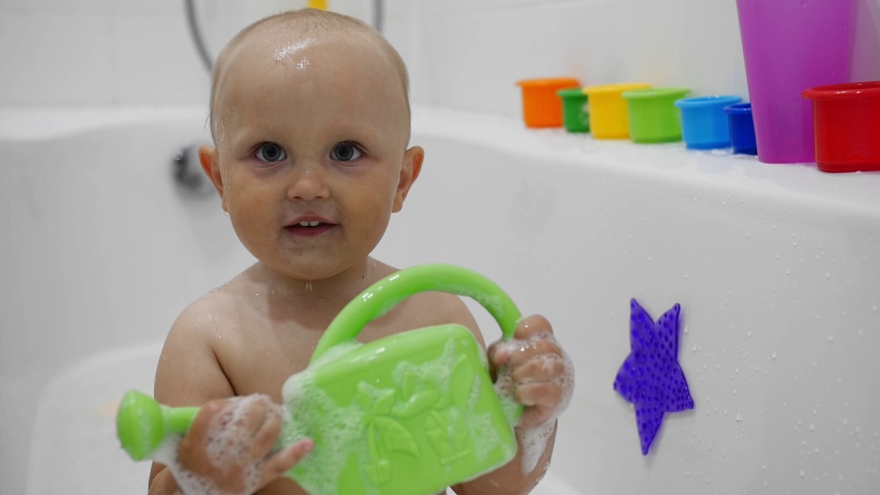 一个胖乎乎的孩子在一个白色的浴缸里洗澡视频下载
