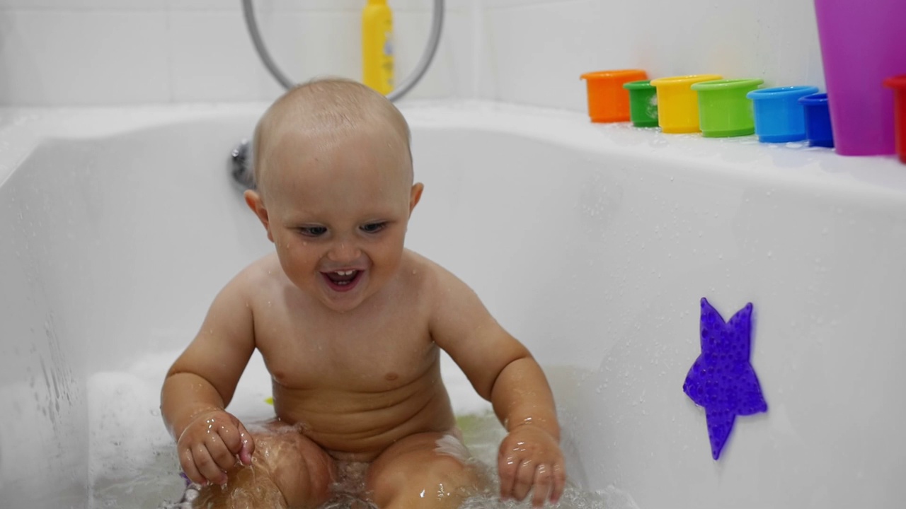 一个胖乎乎的孩子在一个白色的浴缸里洗澡视频下载