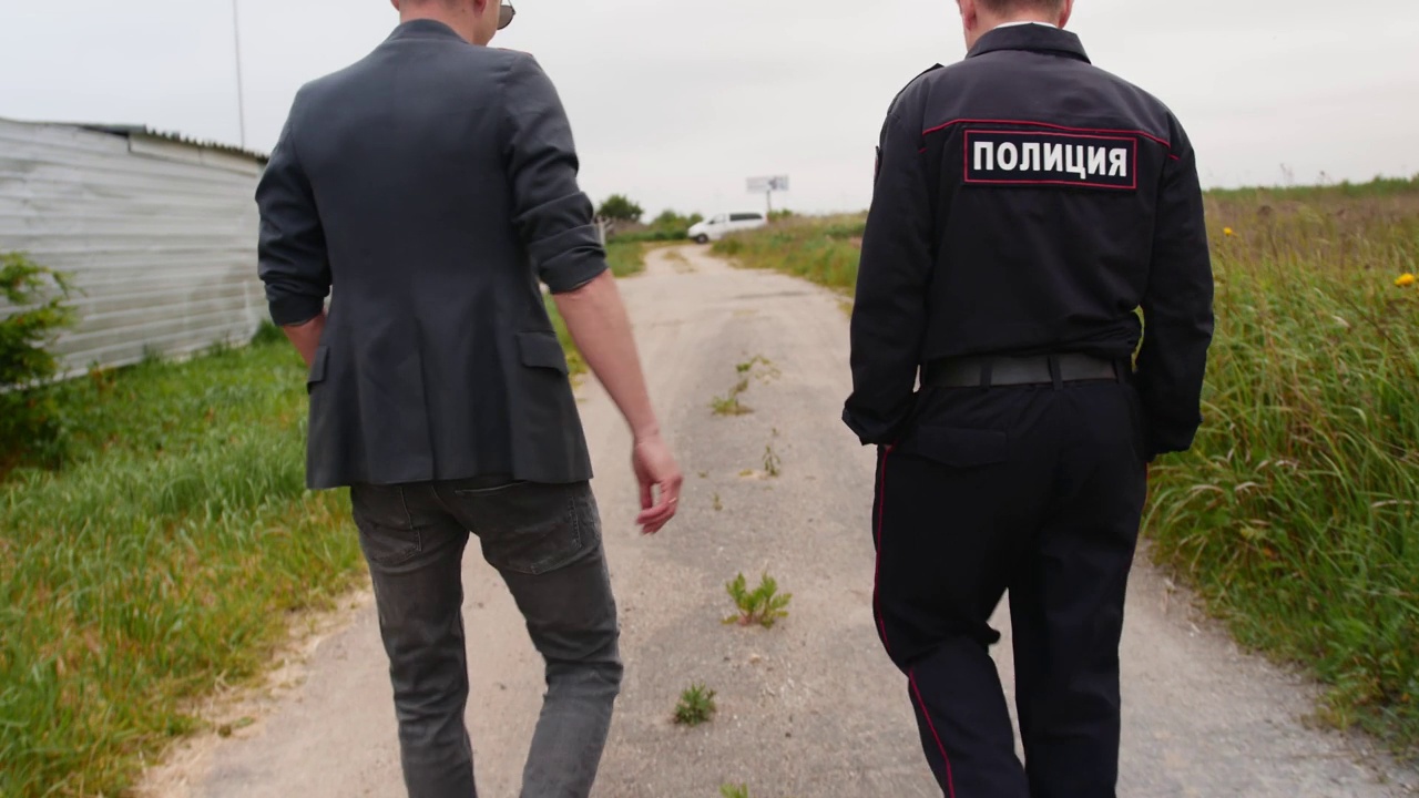 两个俄罗斯警察正沿着乡间的小路走着。视频下载