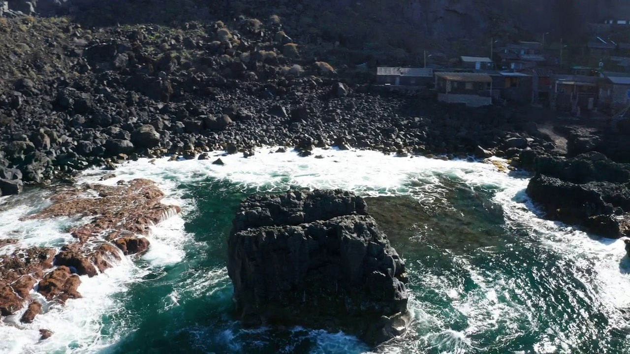 在海浪中，玄武岩柱环绕小岛形成空中弧线视频素材