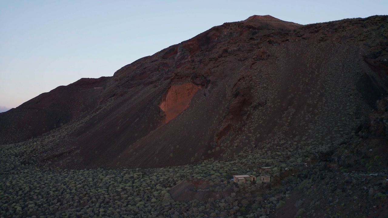 空中摄影车在火山附近的灌木丛和老茅屋之上视频素材