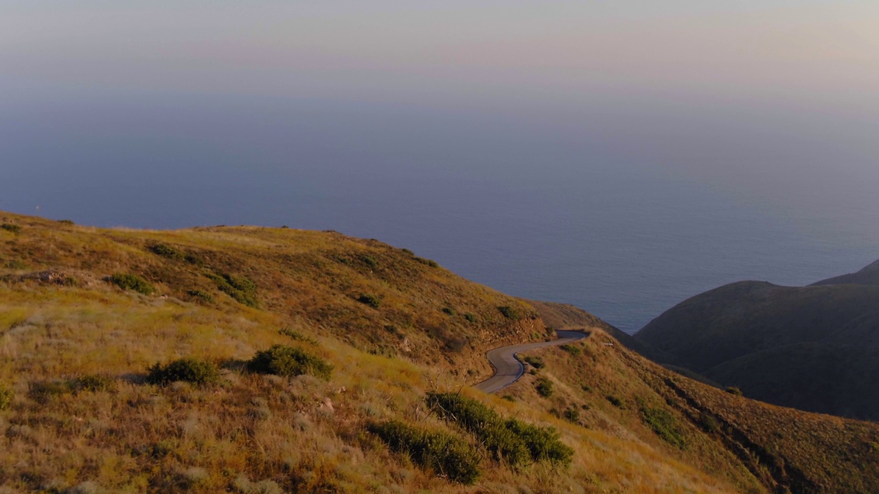 空中向前拍摄的风景，空的弯曲的山路在海上对着清澈的天空-马里布，加利福尼亚视频素材