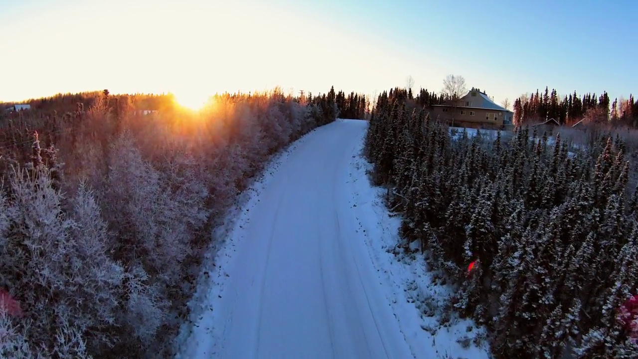 空中前进风景拍摄的雪天道路在森林日落期间-费尔班克斯，阿拉斯加视频素材