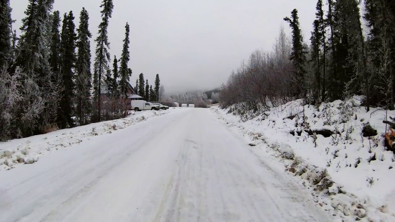 空中拍摄的车辆停在木屋附近，无人机在森林里的雪景飞行-费尔班克斯，阿拉斯加视频素材