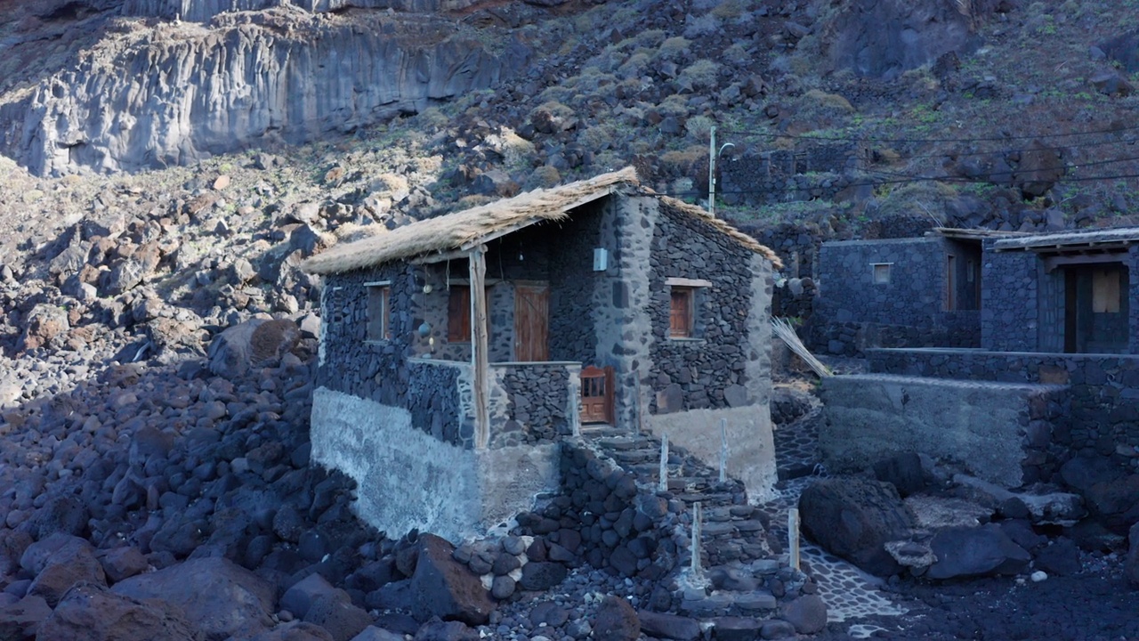 空中手推车步行到黑色火山石和茅草屋顶的钓鱼小屋视频素材