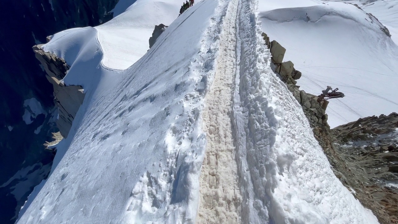 POV相机登山者走在狭窄的山路上，在Aiguille du Midi 3842米与法国阿尔卑斯山山峰全景。自然美和极端人的活动理念视频素材