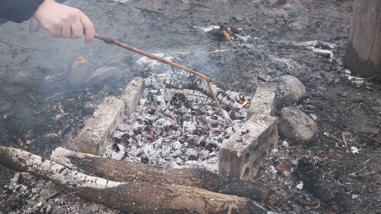 人类调节热煤在自然界中炸肉视频素材