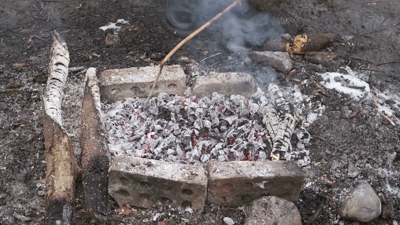 人类调节热煤在自然界中炸肉视频素材