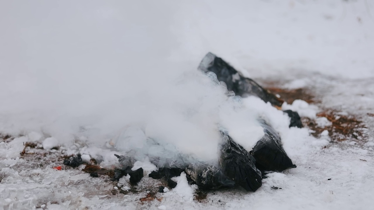 在冬天的雪地里燃起篝火。冬天的野餐。野餐后，火被雪扑灭了。视频素材