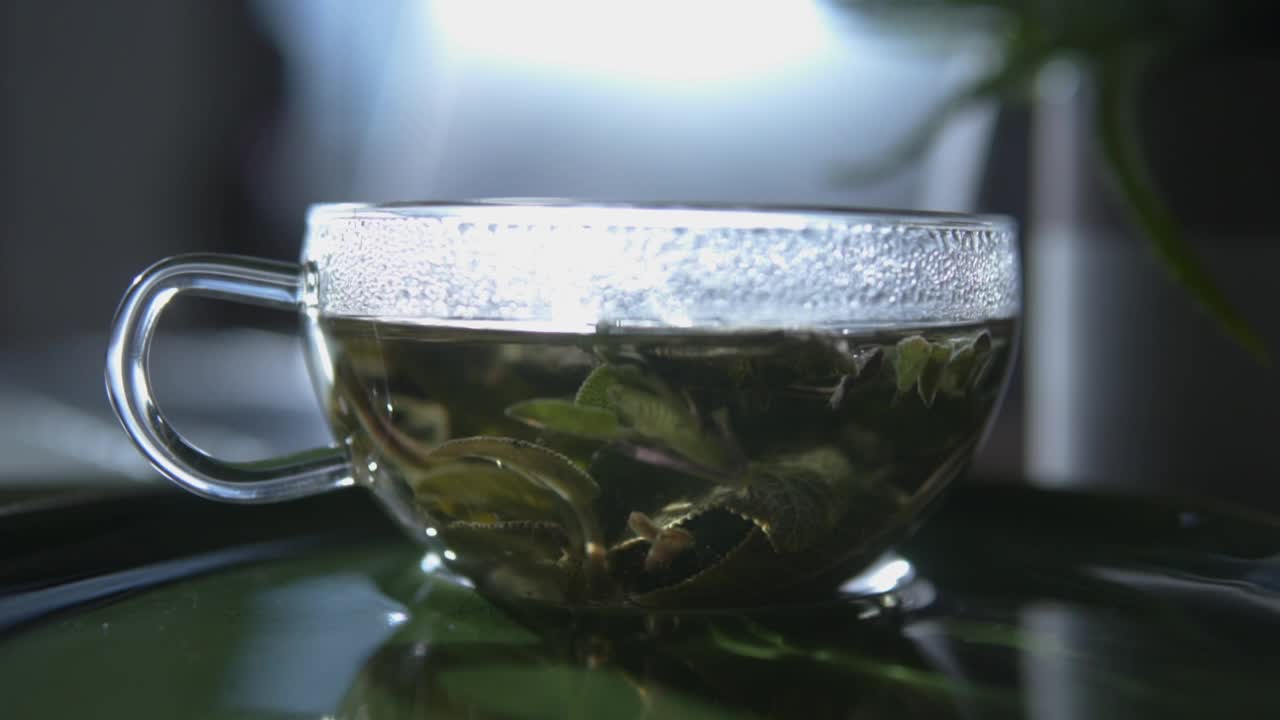 在笔记本电脑前喝杯草本有机茶。视频素材