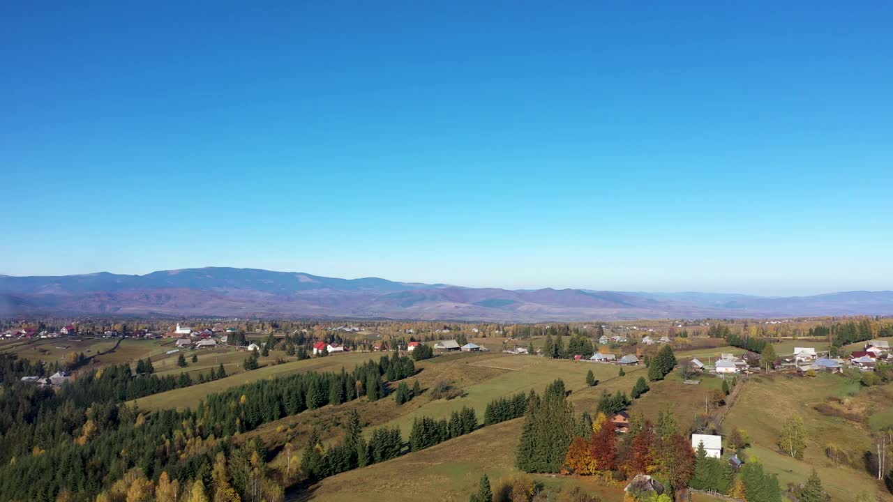 在乡村风景上空飞行。秋天的家园和村庄，树木五彩缤纷视频素材