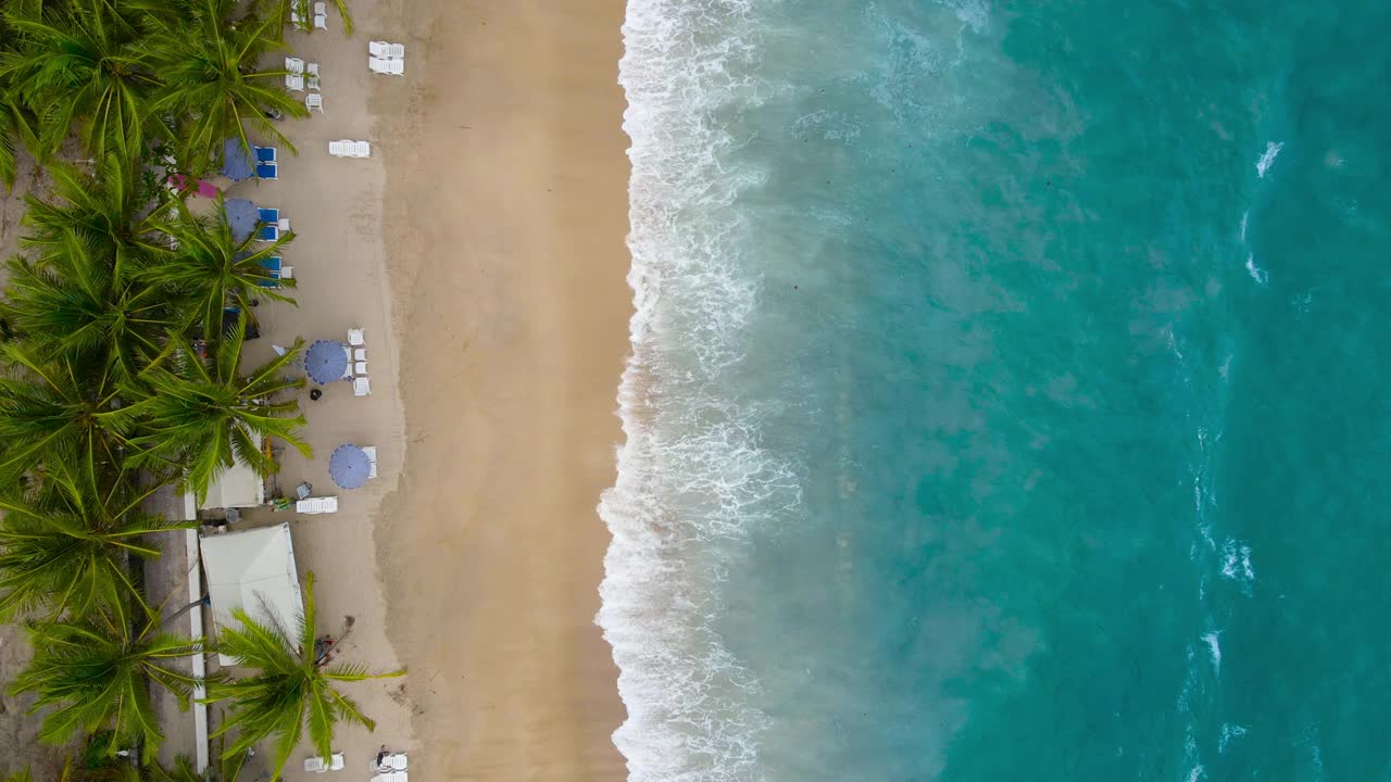 海滩鸟瞰图。白色沙滩的顶部视图。在阳光明媚的日子里，从空中俯瞰美丽的海浪。暑假田园。视频素材