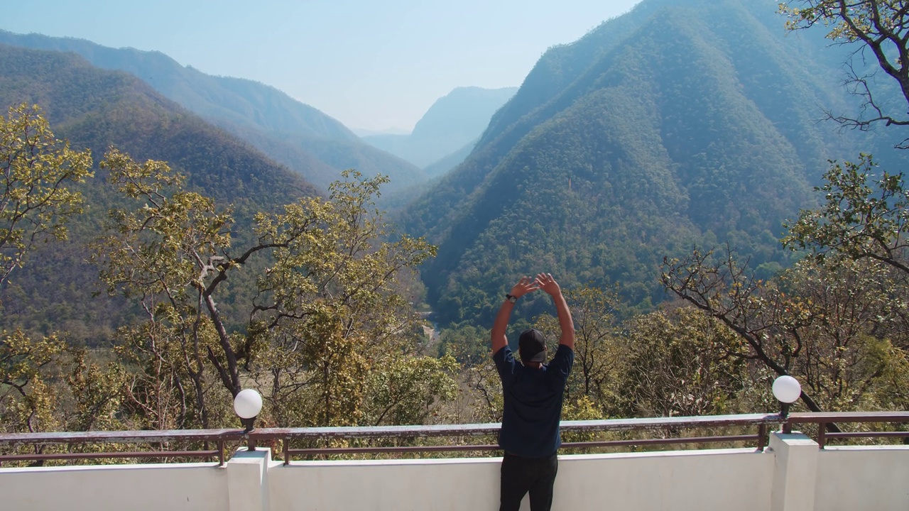 年轻游客游客站在放松享受度假旅行观光自然山脉的背景在泰国北部的人像背面视频素材