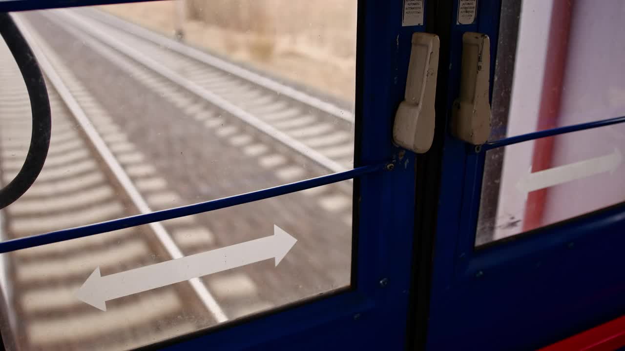 铁路轨道与混凝土铁路枕木和碎石轨道道砟通过客运列车最后车厢门POV视频素材