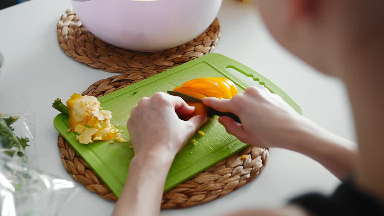 女性手在绿色塑料切菜板上切菜视频下载