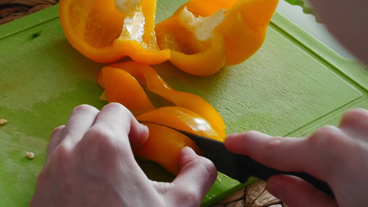 女性手在绿色塑料切菜板上切菜视频下载