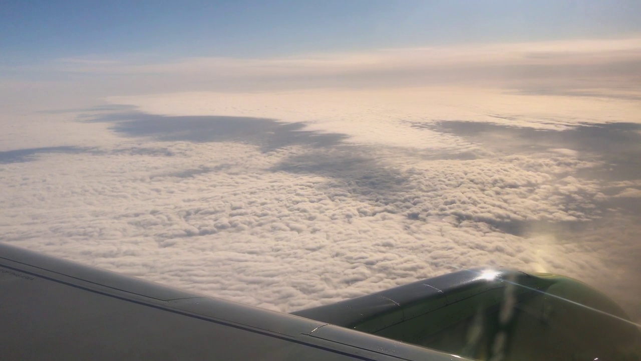 飞机在黎明时分的天空中飞过厚厚的、美丽的云层视频素材