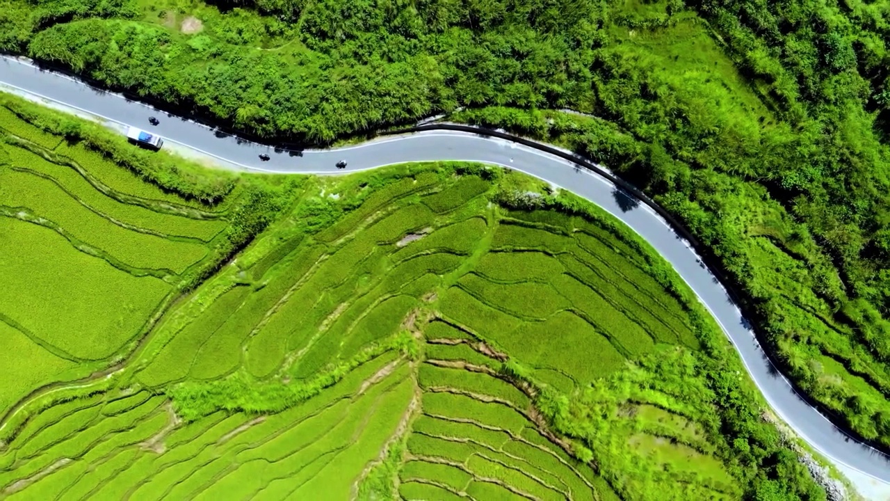 鸟瞰图，摩托车手驾驶摩托车在山区森林道路在乡村边。视频素材