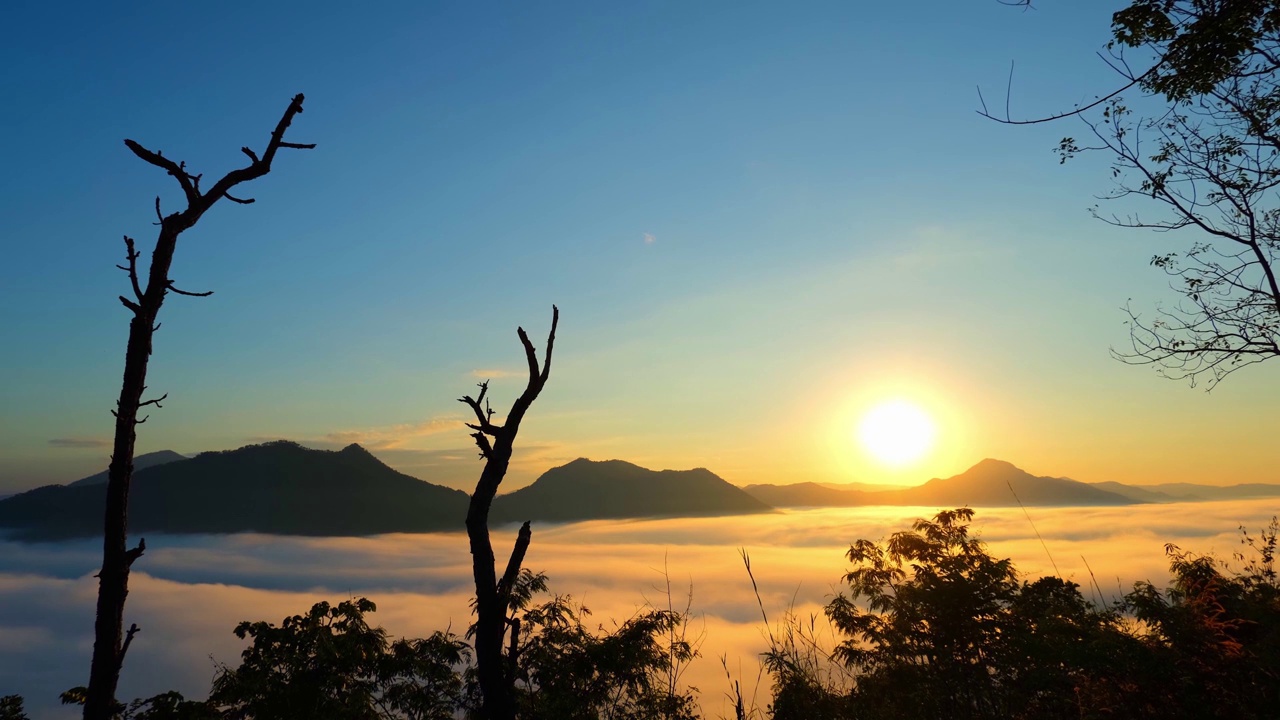 4K:时光飞逝的清晨，浓雾移上了美丽的高山。浪漫美丽的日出视频素材