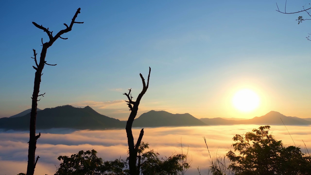 4K:时光飞逝的清晨，浓雾移上了美丽的高山。浪漫美丽的日出视频素材