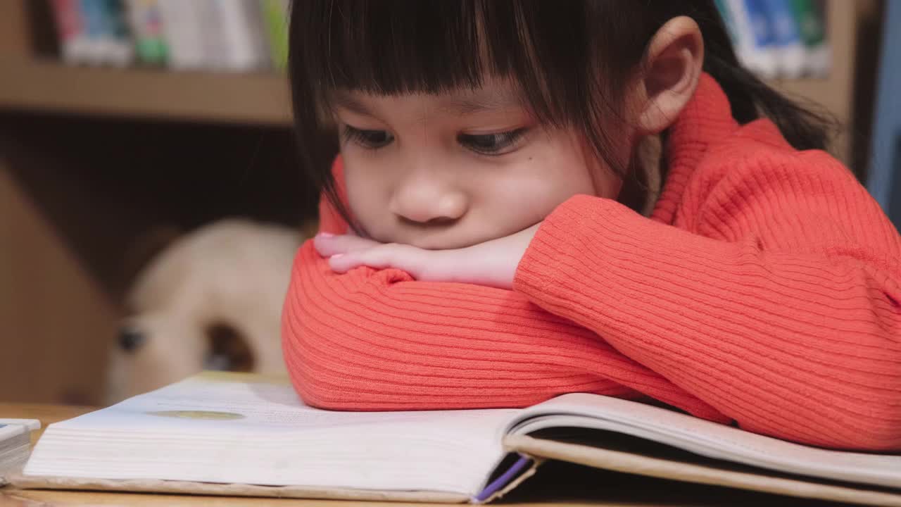 可爱的小女孩正在读书。可爱的亚洲小女孩在家学习，对学习很感兴趣。在家教育的概念视频素材