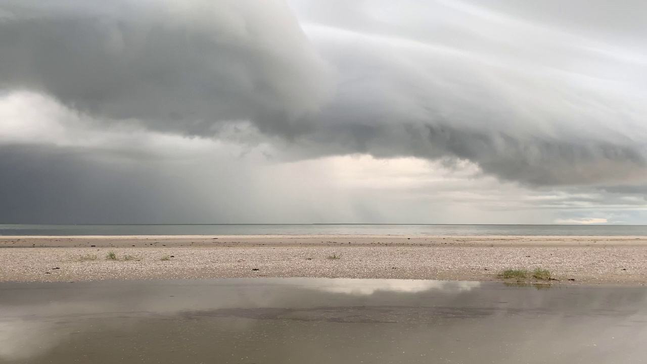 日出时分，在Texel岛的海滩上，一团风暴云正在接近岛屿北角的Wadden海，面对Wadden海和弗利兰。视频素材