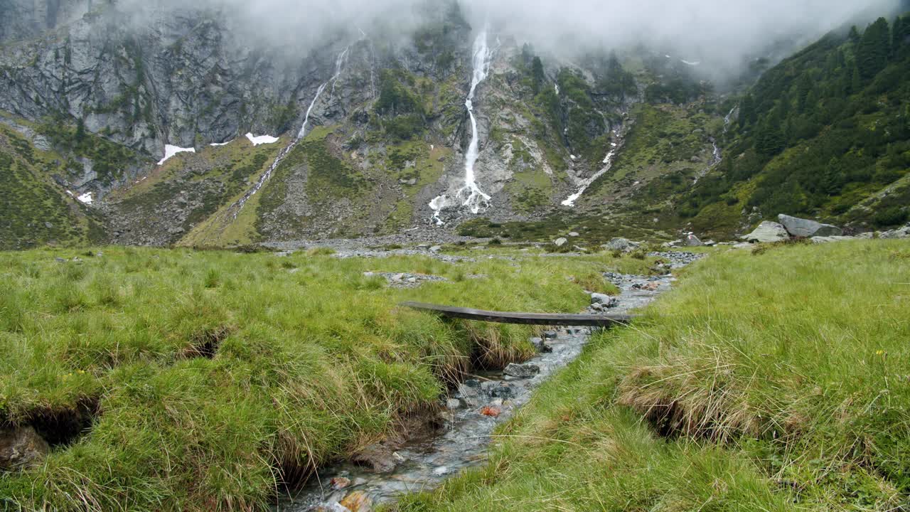 Stubai山谷,奥地利。在美丽的瀑布背景的山间河流上的徒步小径。户外旅游的概念视频素材