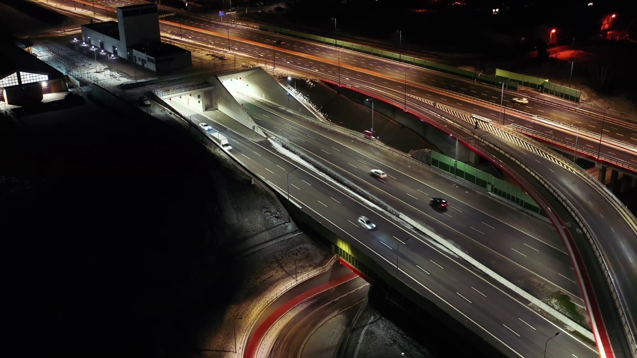 夜间空中立交桥交通拥堵立交道路，夜间无人机拍摄下现代城市道路交叉口的俯视图。许多汽车在繁忙的十字路口高速公路快速行驶视频素材