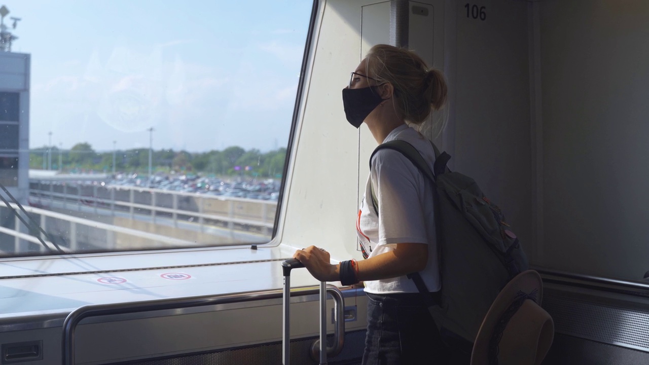 戴着面具的女人乘火车旅行视频素材