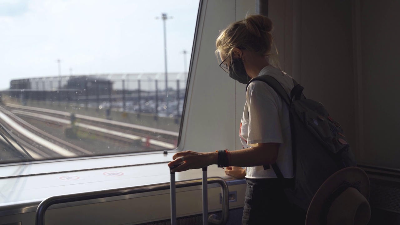 戴着面具的女人乘火车旅行视频素材