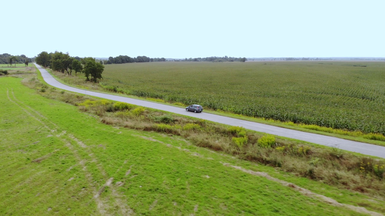 公路在乡村沥青，麦田。鸟瞰图公路旅行旅行旅行假期自然乡村乡村景观。鸟瞰图汽车行驶道路农业田在夏天的一天。视频素材