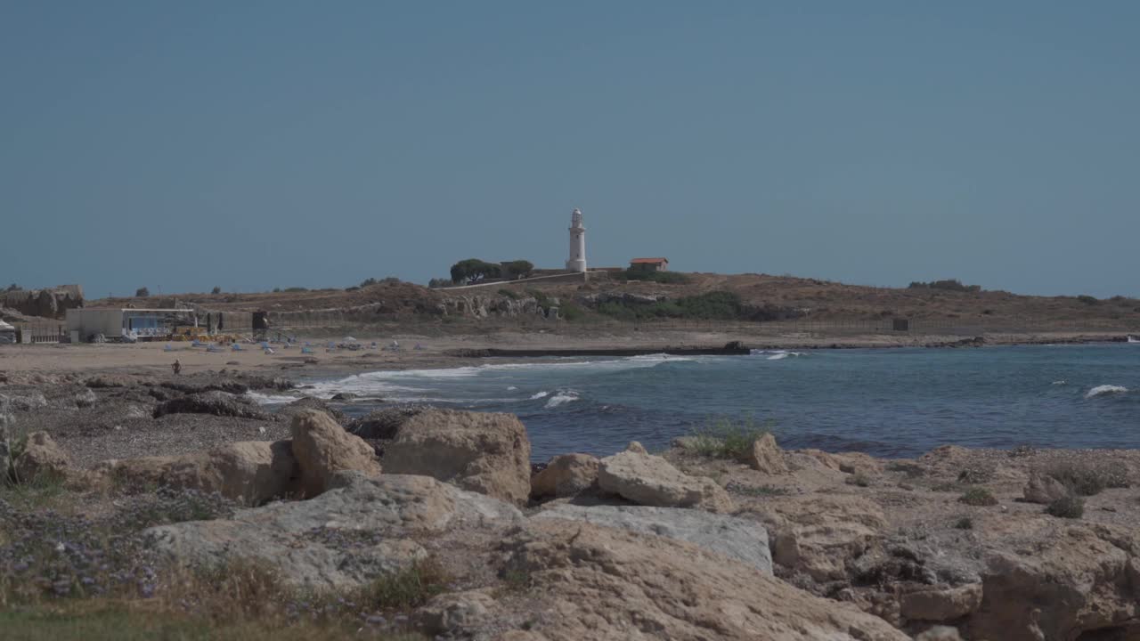 帕福斯地中海岸边的旧灯塔。帕福斯海岸线的著名景点。塞浦路斯岛帕福斯市地中海上的白色旧灯塔。旅行和旅游视频素材