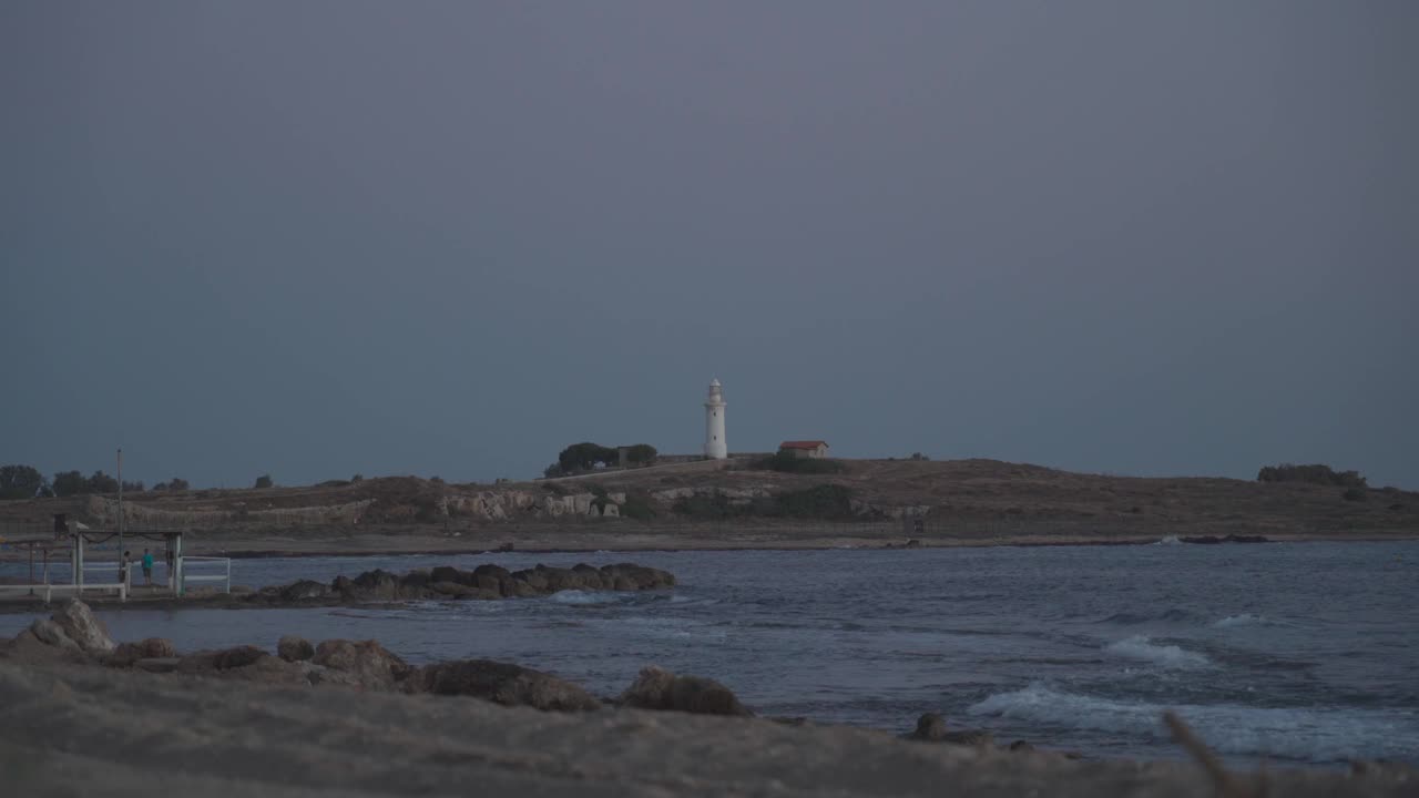 帕福斯地中海岸边的旧灯塔。帕福斯海岸线的著名景点。塞浦路斯岛帕福斯市地中海上的白色旧灯塔。旅行和旅游视频素材