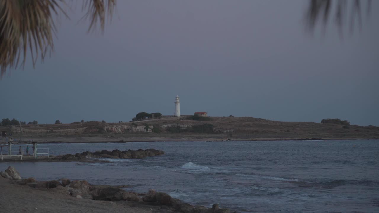 帕福斯地中海岸边的旧灯塔。帕福斯海岸线的著名景点。塞浦路斯岛帕福斯市地中海上的白色旧灯塔。旅行和旅游视频素材