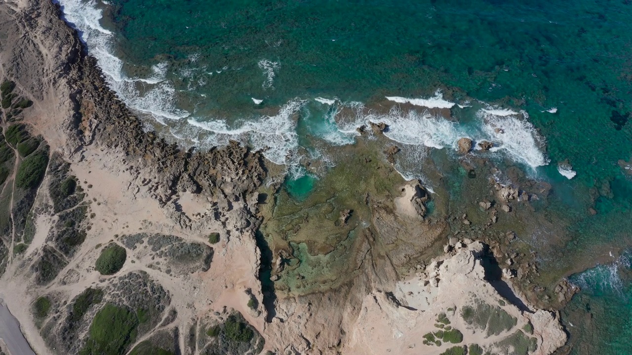 正上方无人机拍摄:热带海滩，海浪拍打岩石海岸的俯视图。视频素材